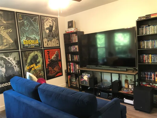 a living room with furniture a flat screen tv and a floor to ceiling window