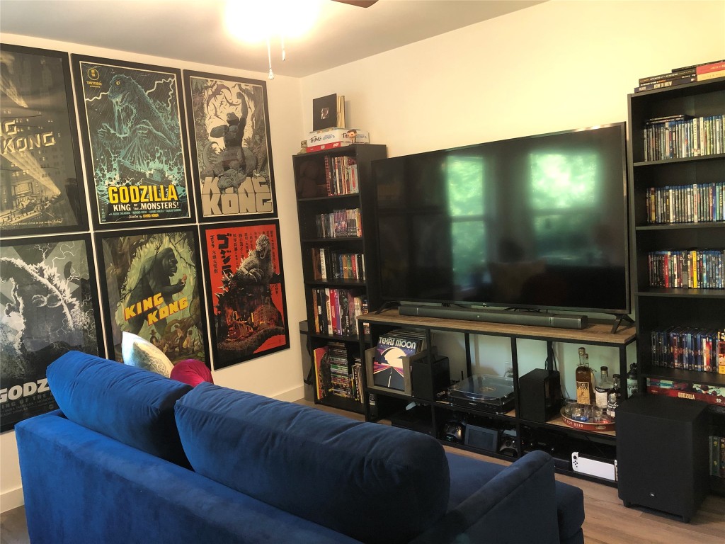 6409 Burns Street, Unit 306 Austin, TX 78752 - Photo 12 of 24 a living room with furniture a flat screen tv and a floor to ceiling window