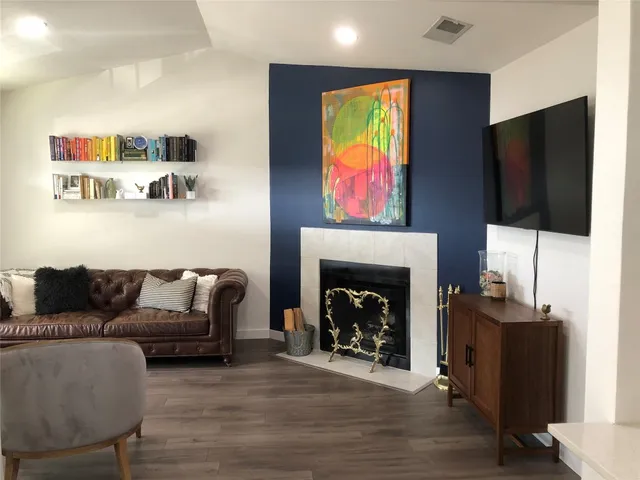 a living room with furniture a flat screen tv and a fireplace