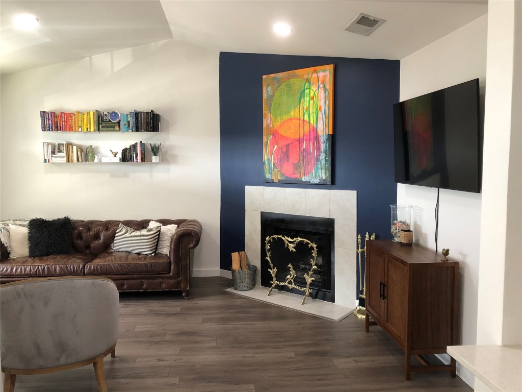 6409 Burns Street, Unit 306 Austin, TX 78752 - Photo 3 of 24 a living room with furniture a flat screen tv and a fireplace