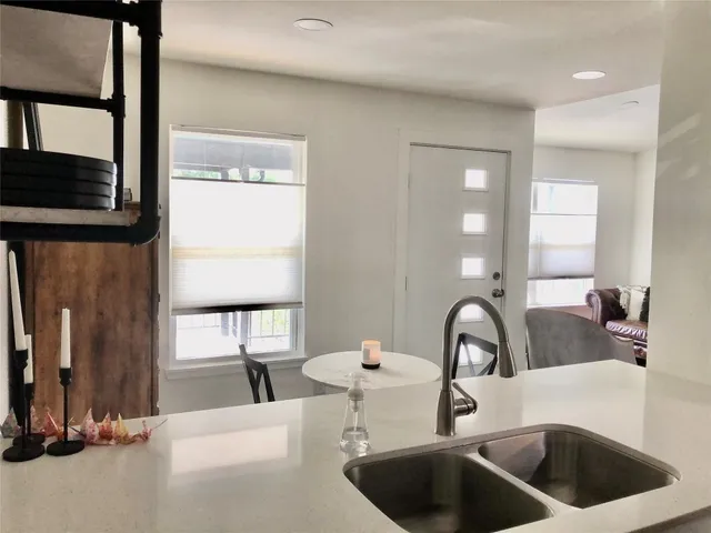 a kitchen with a sink and a large mirror next to a window