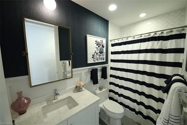 a bedroom with a bed and a flat tv screen on the dresser