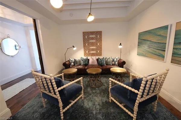 a dining room with furniture a chandelier and wooden floor