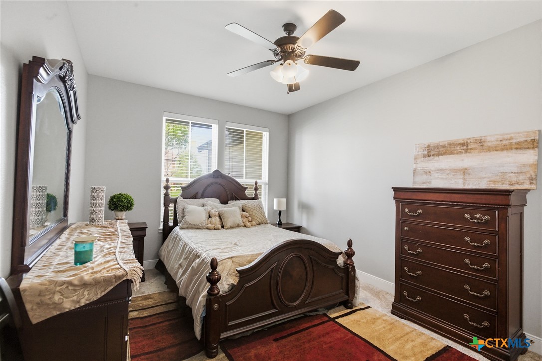 113 Terra Vista Ranch Road Victoria, TX 77904 - Photo 32 of 47 a bedroom with a bed and a chandelier