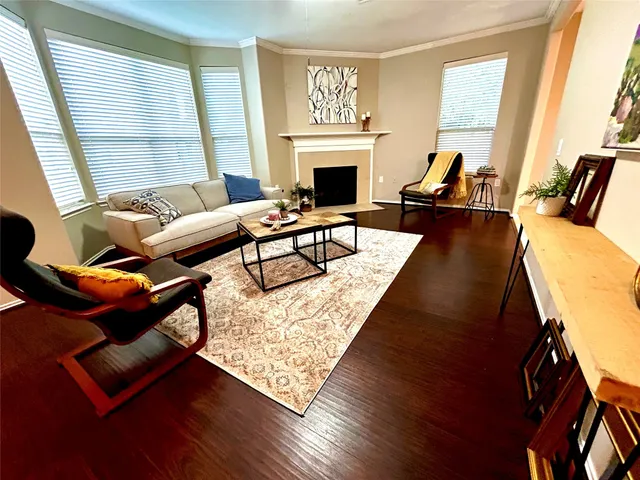 a living room with furniture fireplace and a large window