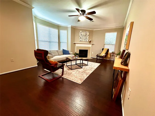 a living room with furniture a fireplace and a large window