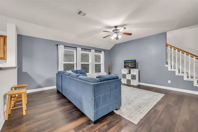 a living room with furniture and wooden floor