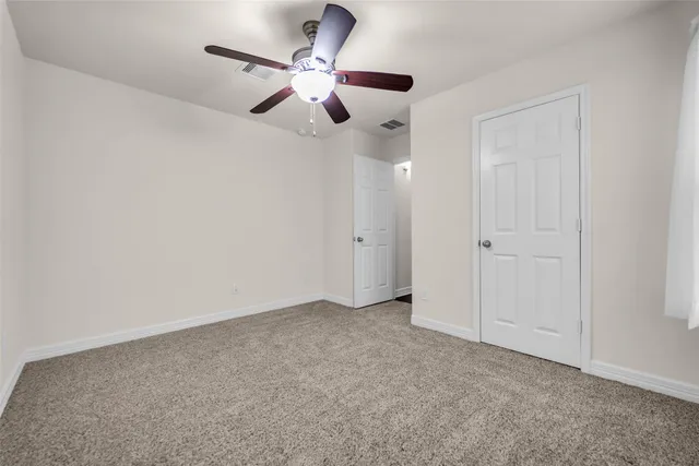 an empty room with chandelier fan