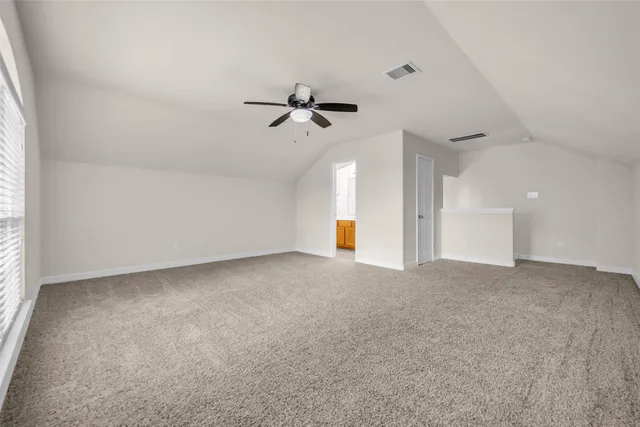 an empty room with a ceiling fan and window