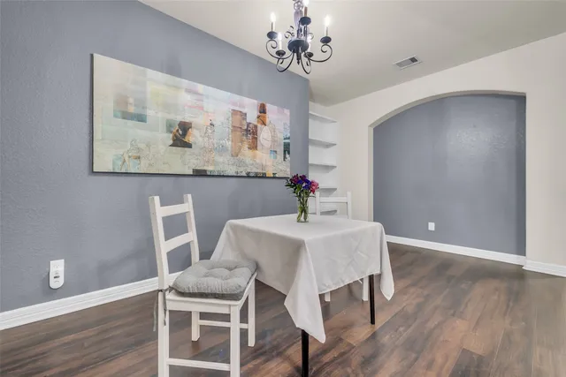 a view of a dining room with furniture wooden floor and a chandelier