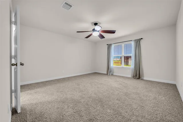 a view of a room with a ceiling fan and a window