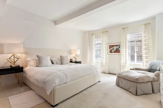 a spacious bedroom with a bed and glass window