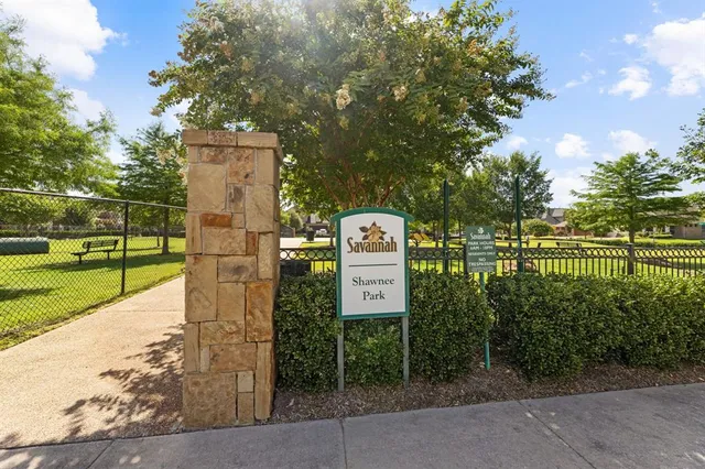 a sign board with a park park in back