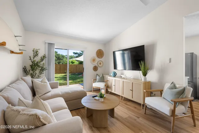 a living room with furniture a flat screen tv and a large window