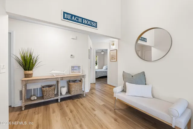 a living room with furniture a mirror and a potted plant