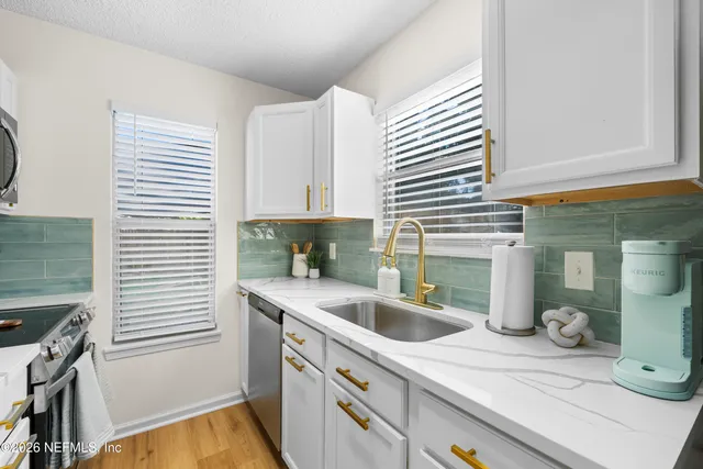 a kitchen with a sink cabinets and window