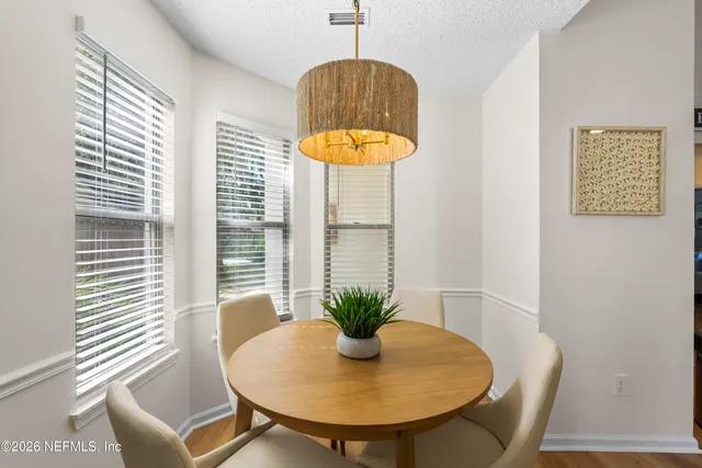 a view of a dining room with furniture and a window