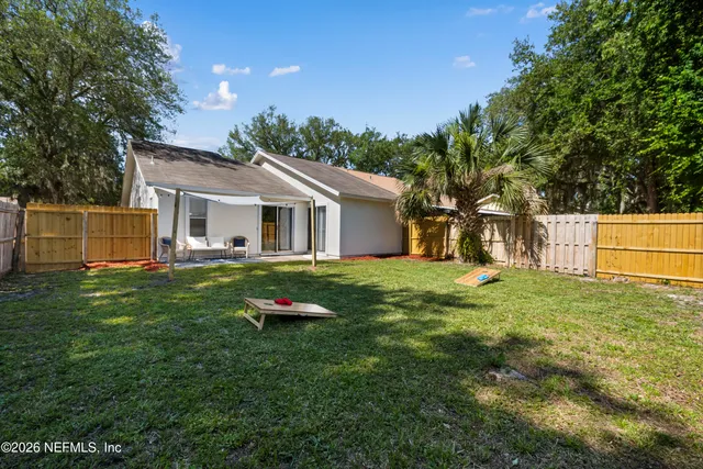 a backyard of a house with table and chairs
