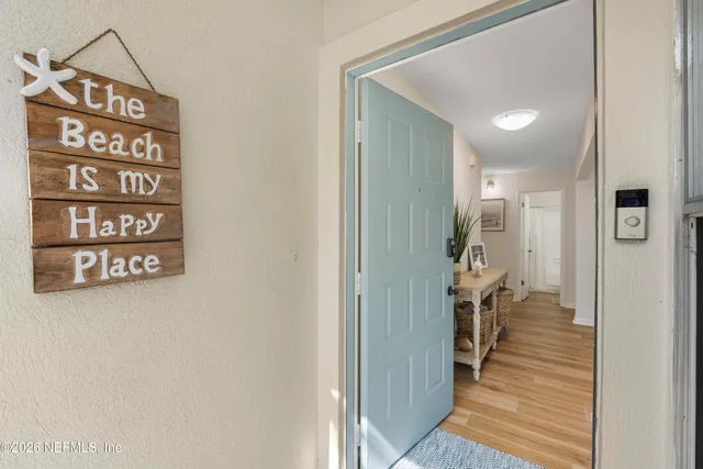 a view of a hallway with wooden floor and a bathroom