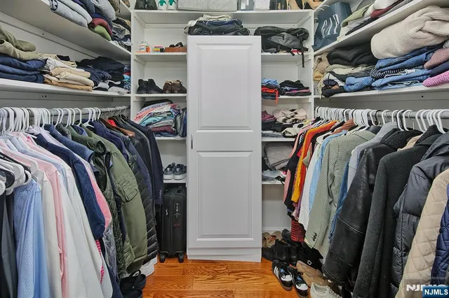 a view of walk in closet with clothes and shoes
