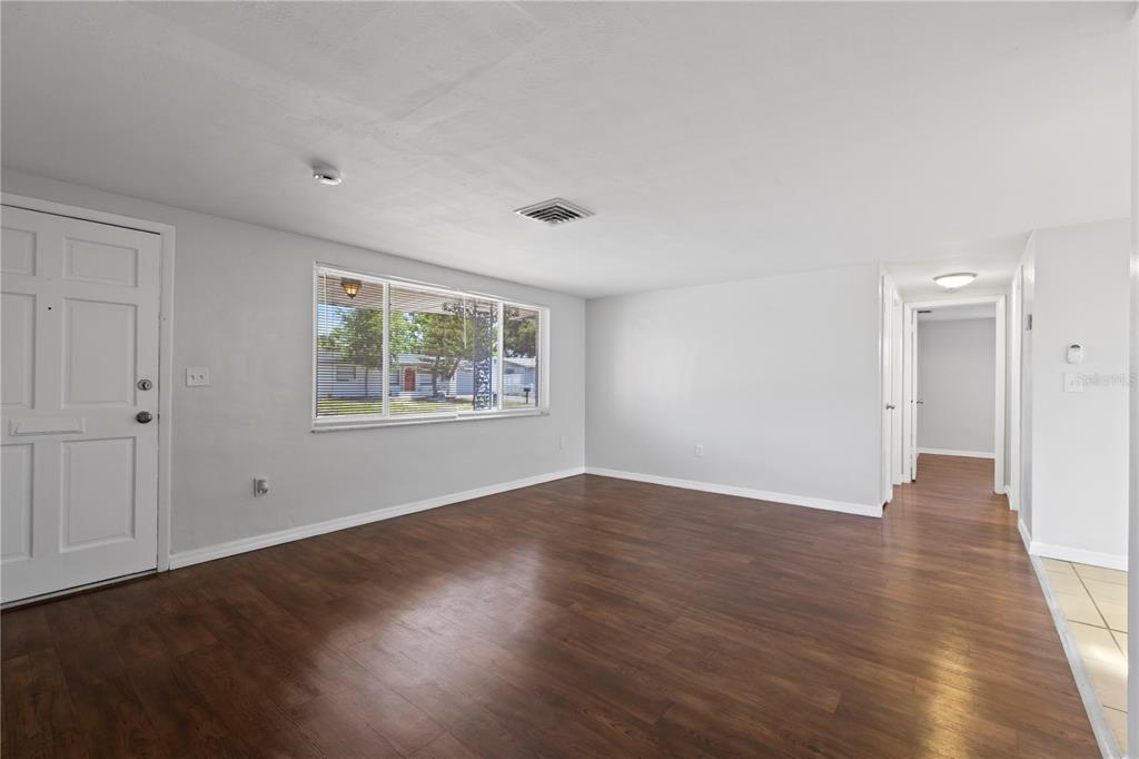 7330 Abalone Drive Port Richey, FL 34668 - Photo 13 of 49 a view of an empty room with wooden floor and a window