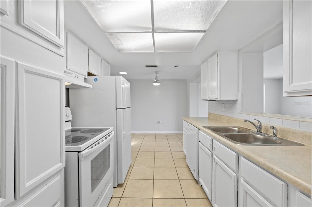 7330 Abalone Drive Port Richey, FL 34668 - Photo 16 of 49 a kitchen with granite countertop a sink stainless steel appliances and cabinets