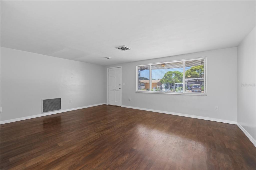 7330 Abalone Drive Port Richey, FL 34668 - Photo 30 of 49 a view of an empty room with wooden floor and a window