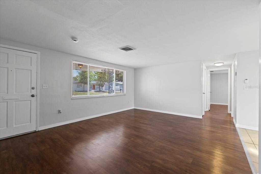 7330 Abalone Drive Port Richey, FL 34668 - Photo 4 of 49 a view of an empty room with wooden floor and a window