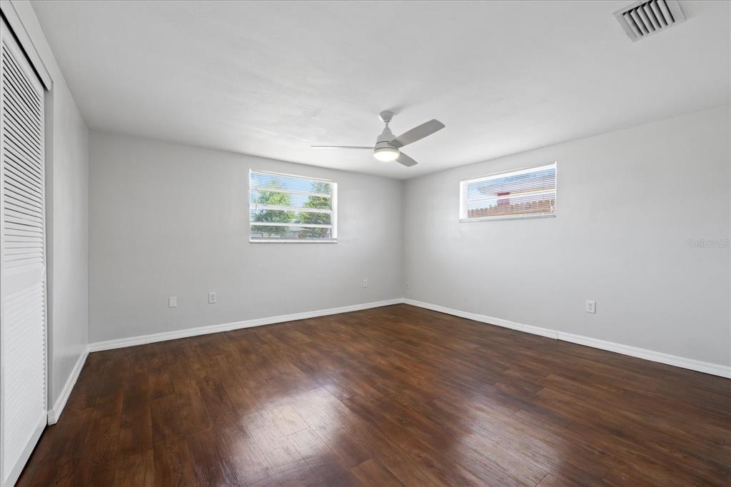 7330 Abalone Drive Port Richey, FL 34668 - Photo 8 of 49 wooden floor in an empty room with a window