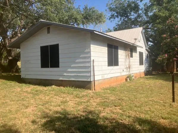 a view of house with backyard outdoor seating and hardwood