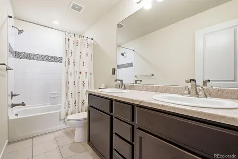 a bathroom with a granite countertop sink a toilet and bathtub