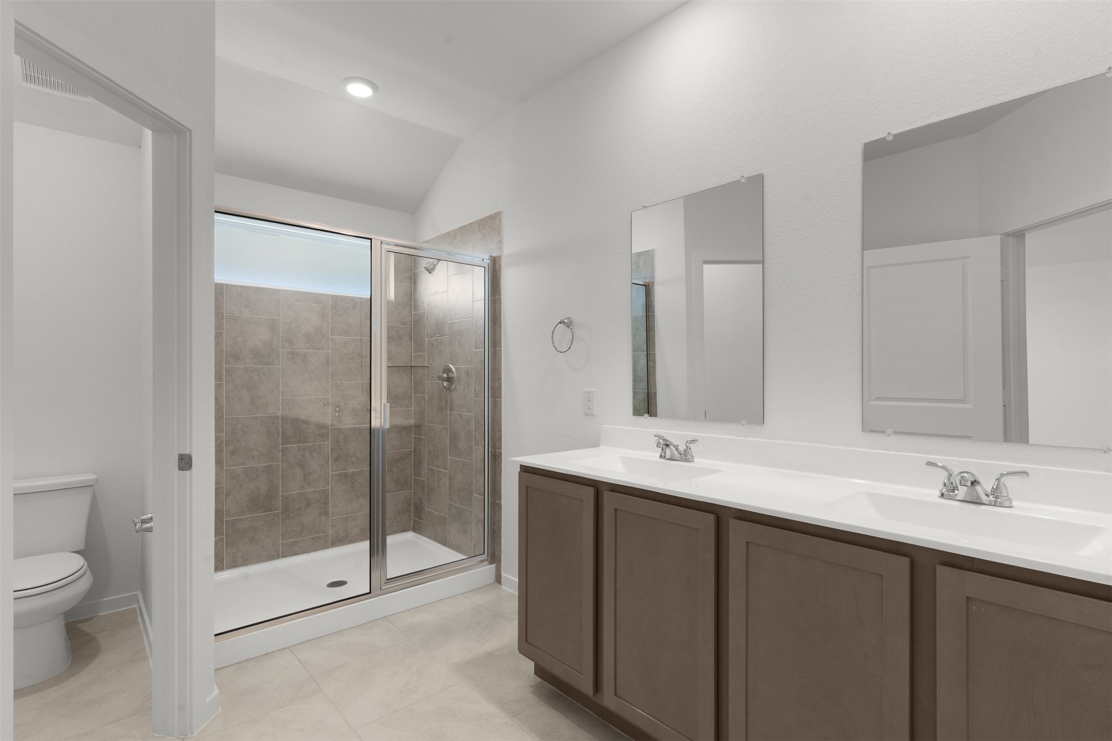 13832 Scarlett Song Drive Elgin, TX 78621 - Photo 13 of 26 Full bath with double vanity, a stall shower, light tile patterned floors, and lofted ceiling