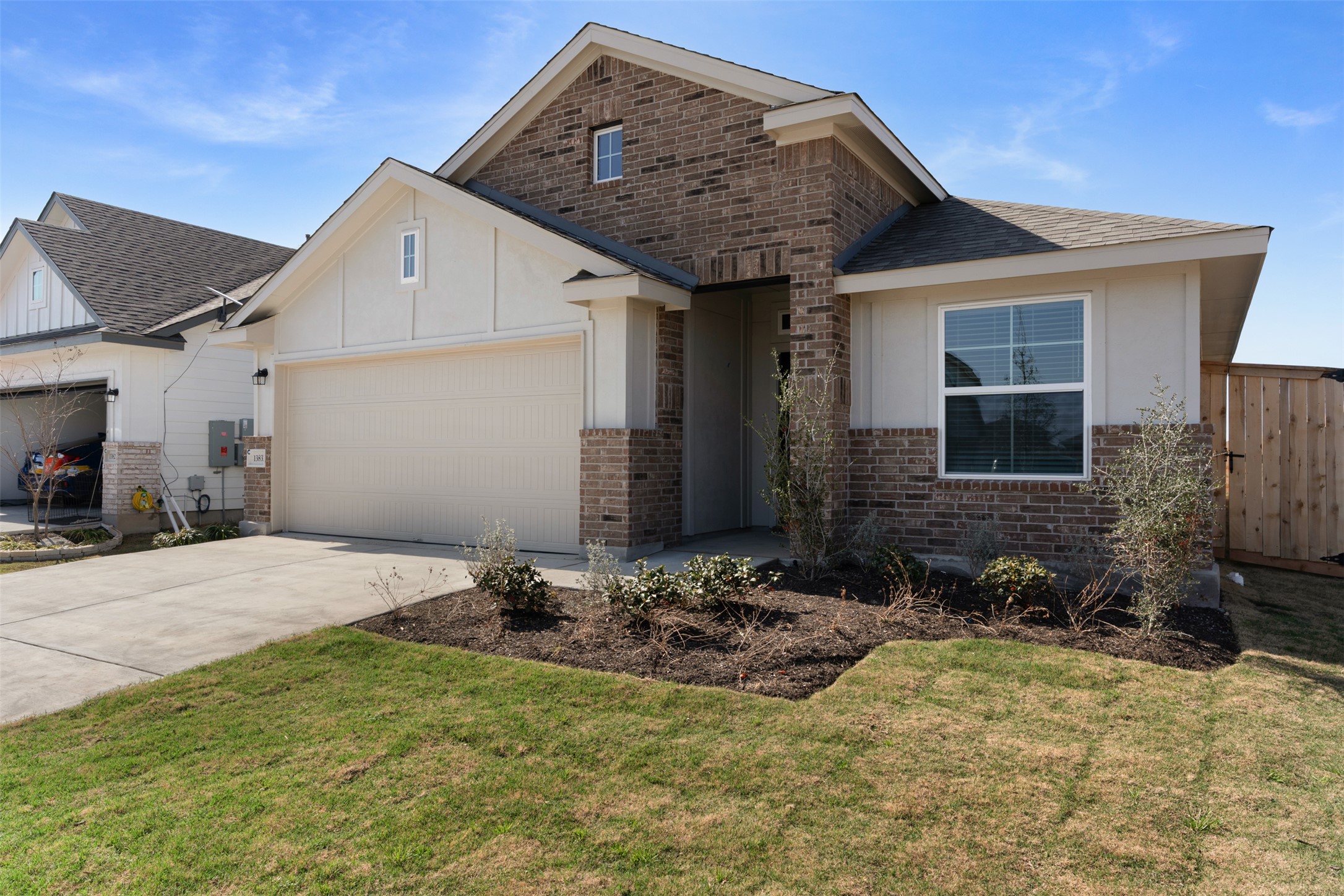 13832 Scarlett Song Drive Elgin, TX 78621 - Photo 2 of 26 View of front facade with concrete driveway, brick siding, roof with shingles, and an attached garage