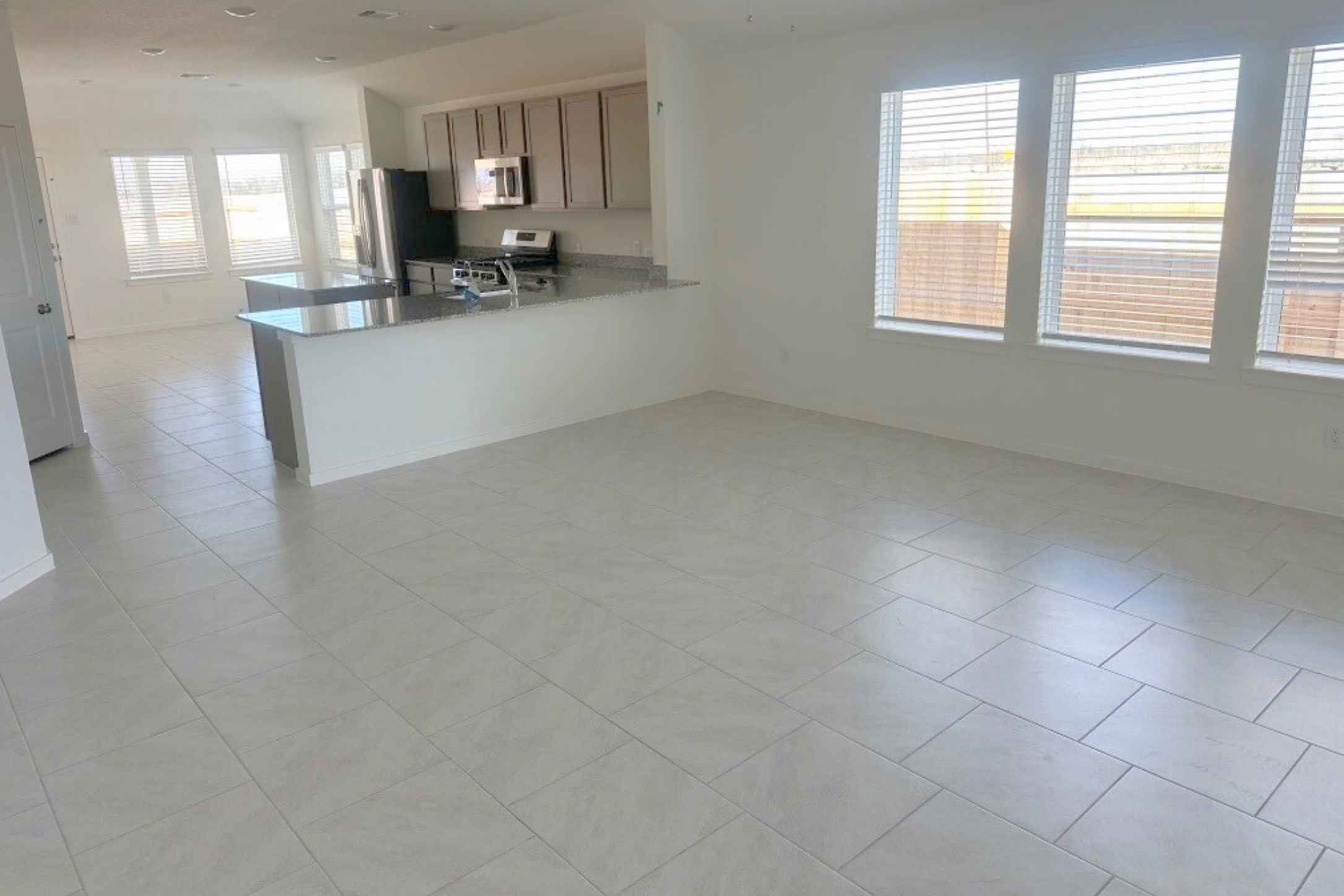 13832 Scarlett Song Drive Elgin, TX 78621 - Photo 18 of 19 Kitchen featuring a peninsula, light tile patterned floors, stainless steel appliances, and open floor plan