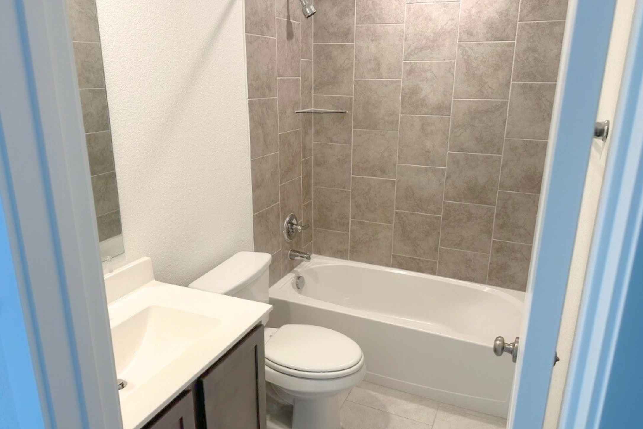 13832 Scarlett Song Drive Elgin, TX 78621 - Photo 5 of 19 Bathroom with vanity, bathtub / shower combination, a textured wall, and light tile patterned floors