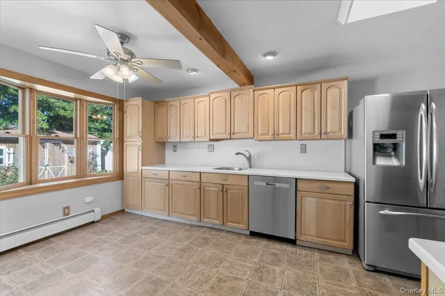 a kitchen that has a lot of cabinets in it and stainless steel appliances