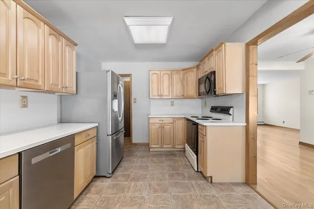 a kitchen with stainless steel appliances granite countertop a stove top oven a refrigerator a sink and dishwasher with white cabinets