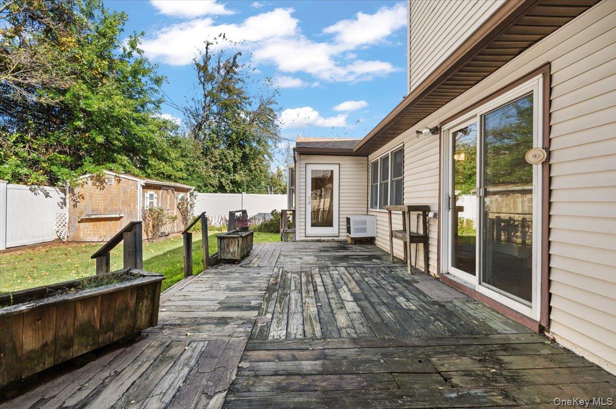 3 Surrey Lane Bethpage, NY 11714 - Photo 25 of 33 a view of a deck with chairs a barbeque with wooden floor and fence