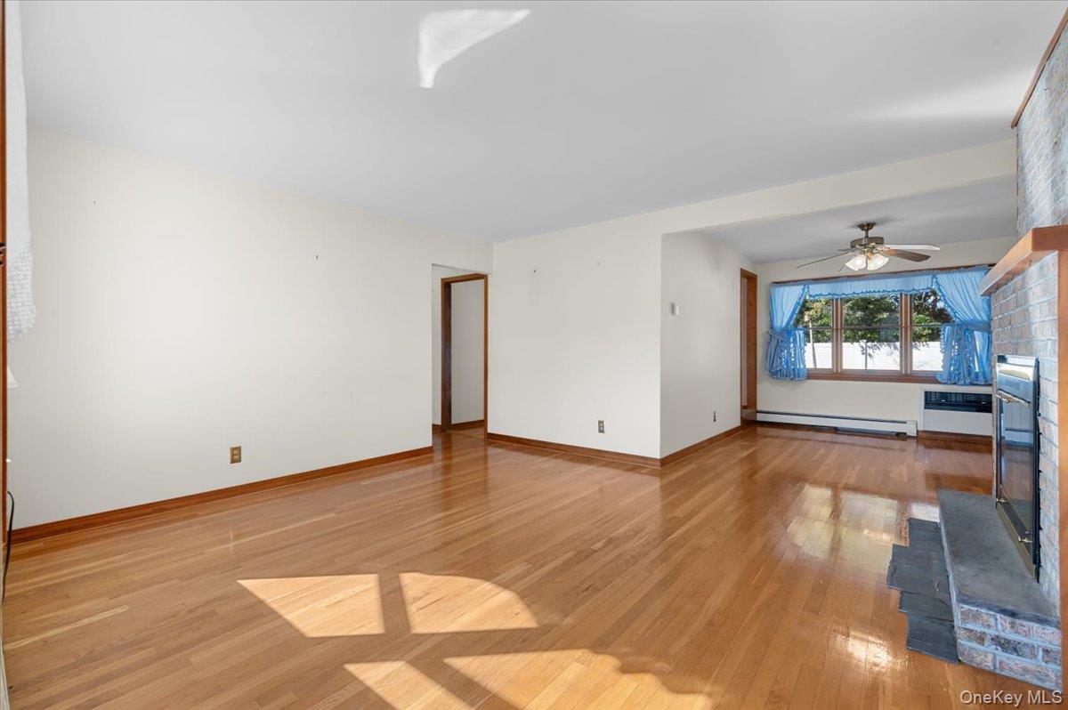 3 Surrey Lane Bethpage, NY 11714 - Photo 3 of 33 a view of empty room with wooden floor and fireplace