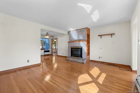 an empty room with wooden floor and a fireplace