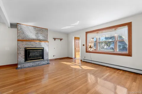 an empty room with large windows and fireplace