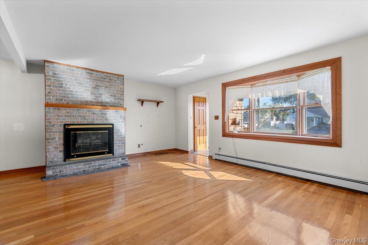 3 Surrey Lane Bethpage, NY 11714 - Photo 5 of 33 an empty room with large windows and fireplace