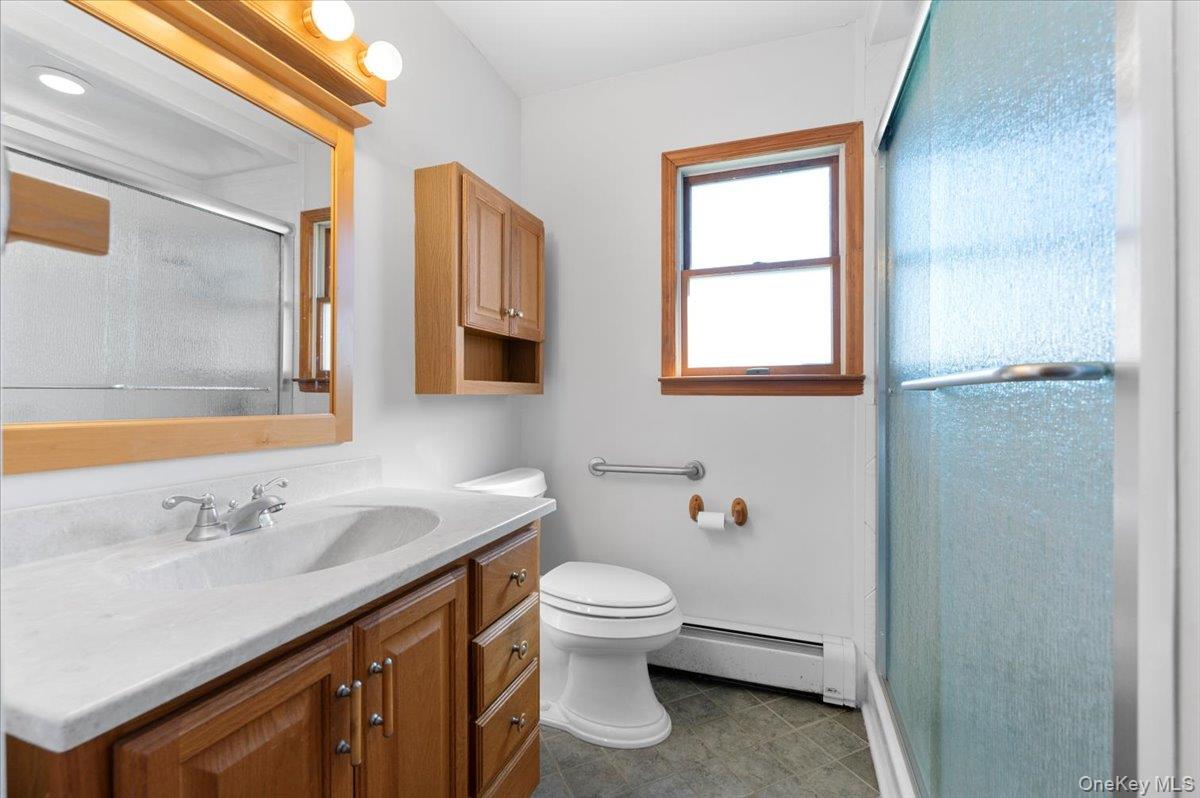 3 Surrey Lane Bethpage, NY 11714 - Photo 6 of 33 a bathroom with a sink a toilet and mirror