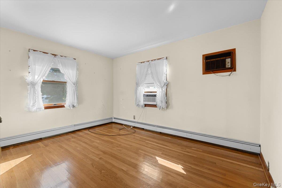 3 Surrey Lane Bethpage, NY 11714 - Photo 7 of 33 a view of an empty room with wooden floor and a window