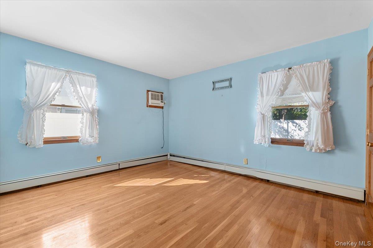 3 Surrey Lane Bethpage, NY 11714 - Photo 9 of 33 an empty room with wooden floor and windows