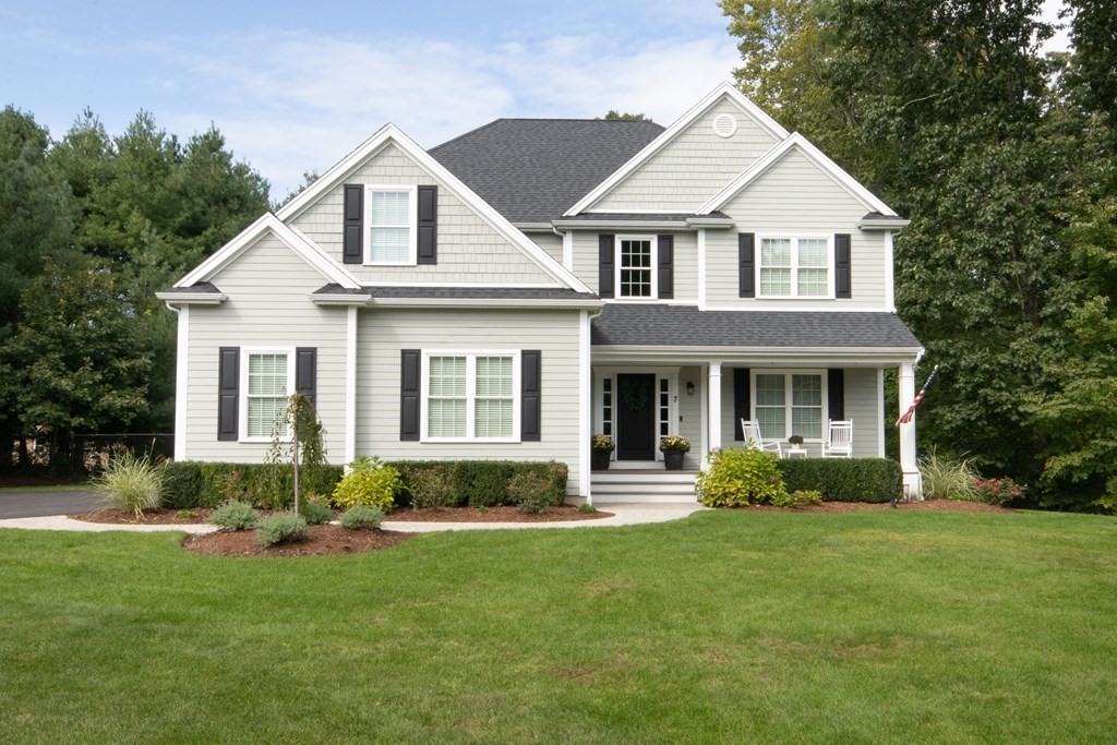 a front view of a house with a yard and green space