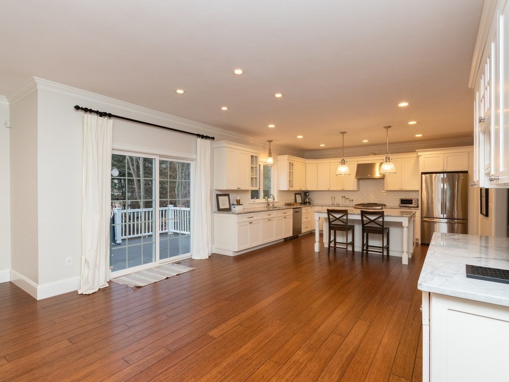 7 Garrett Spillane Road Foxboro, MA 02035 - Photo 8 of 36 an open kitchen with wooden floor and a refrigerator