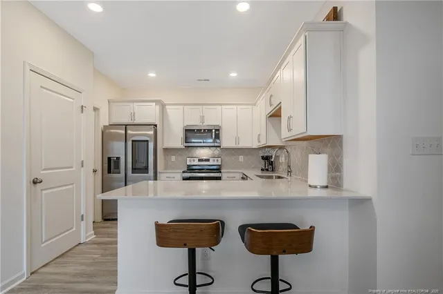 a kitchen with stainless steel appliances granite countertop a refrigerator and a stove top oven