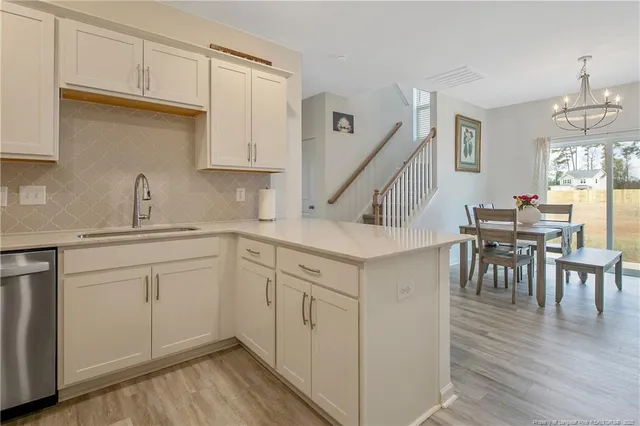 a kitchen with white cabinets and wooden floors