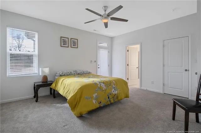 a spacious bedroom with a bed and a ceiling fan